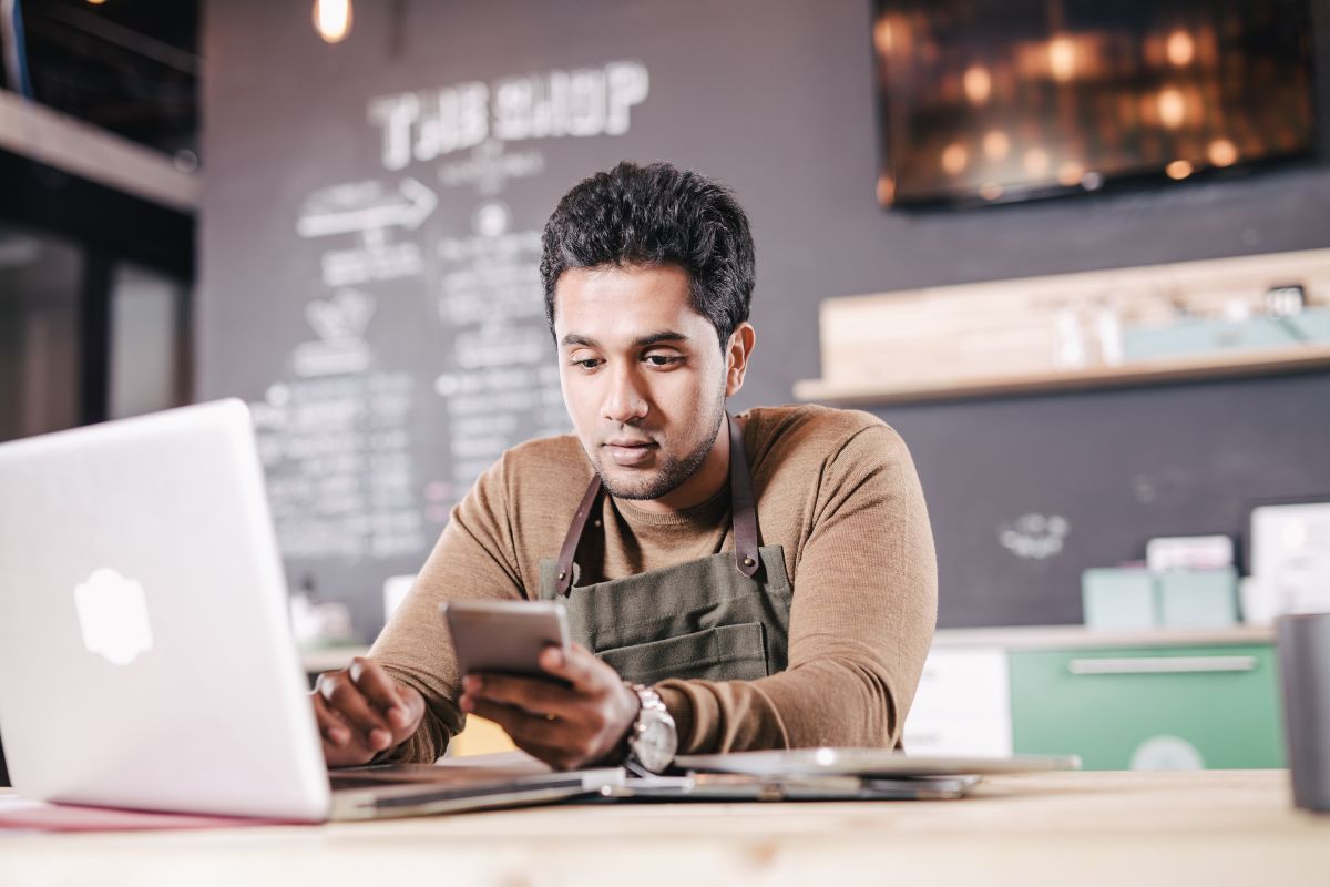 hombre en cafetería viendo los tipos de impuestos en su computador